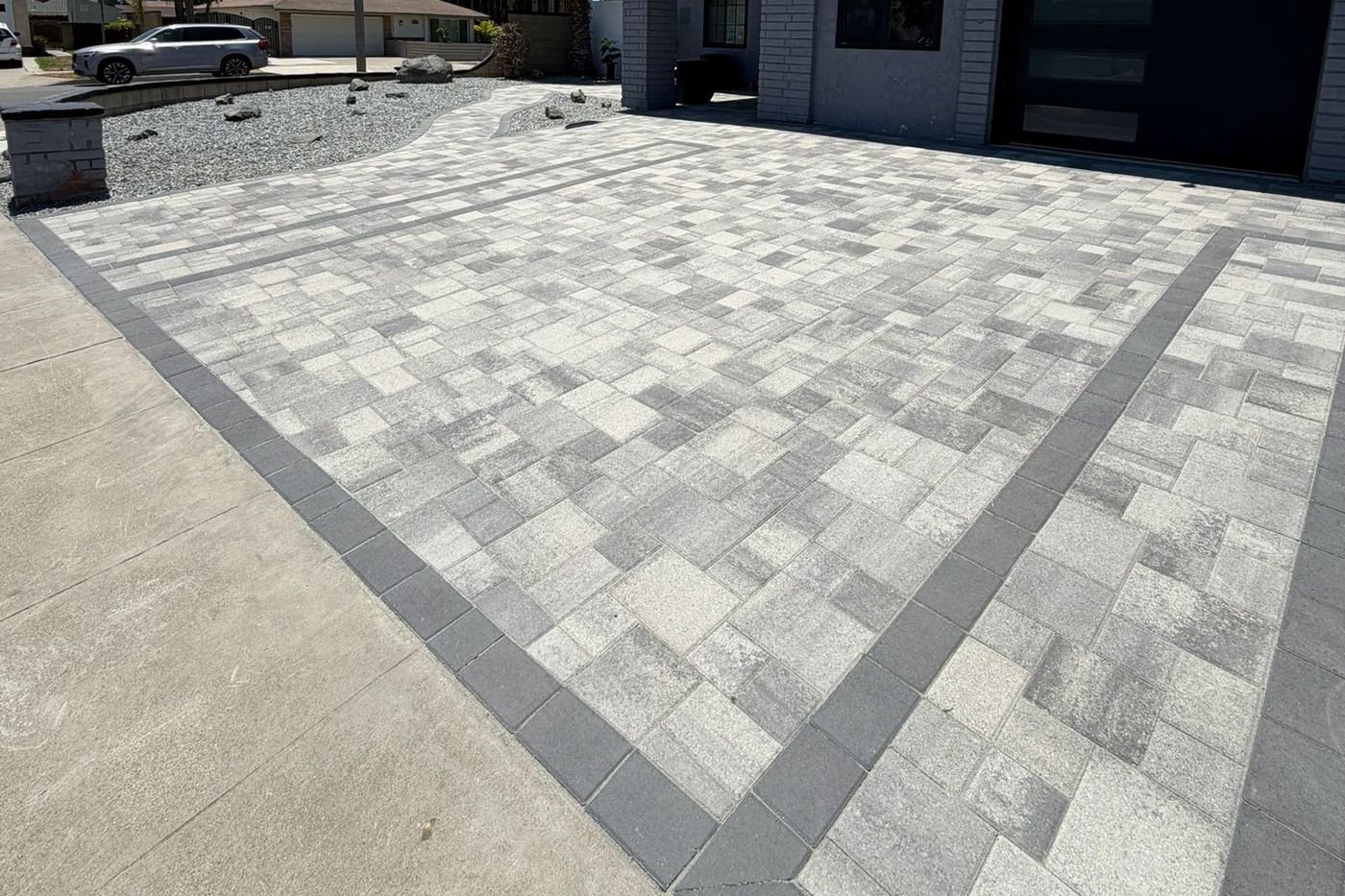 Paver driveway with a charcoal border installed by Option 1 Builders
