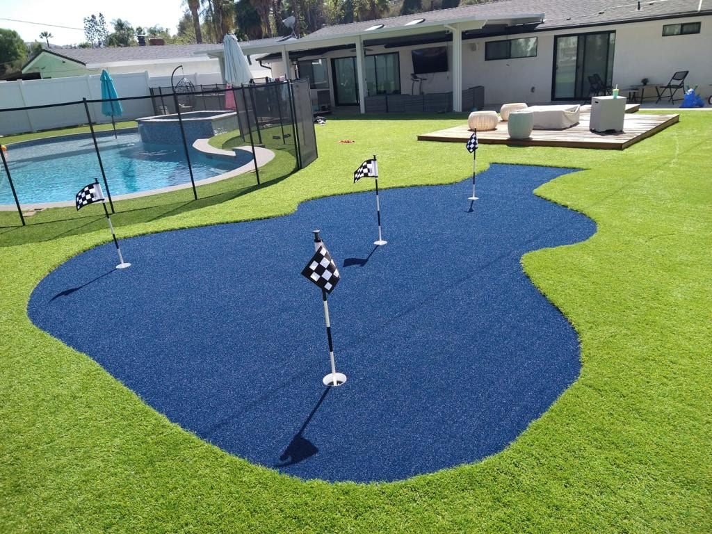 Backyard putting green beside a pool in Lake Balboa by Option 1 Builders
