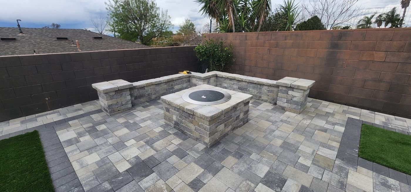 Paver patio with a fire pit and seat wall built by Option 1 Builders