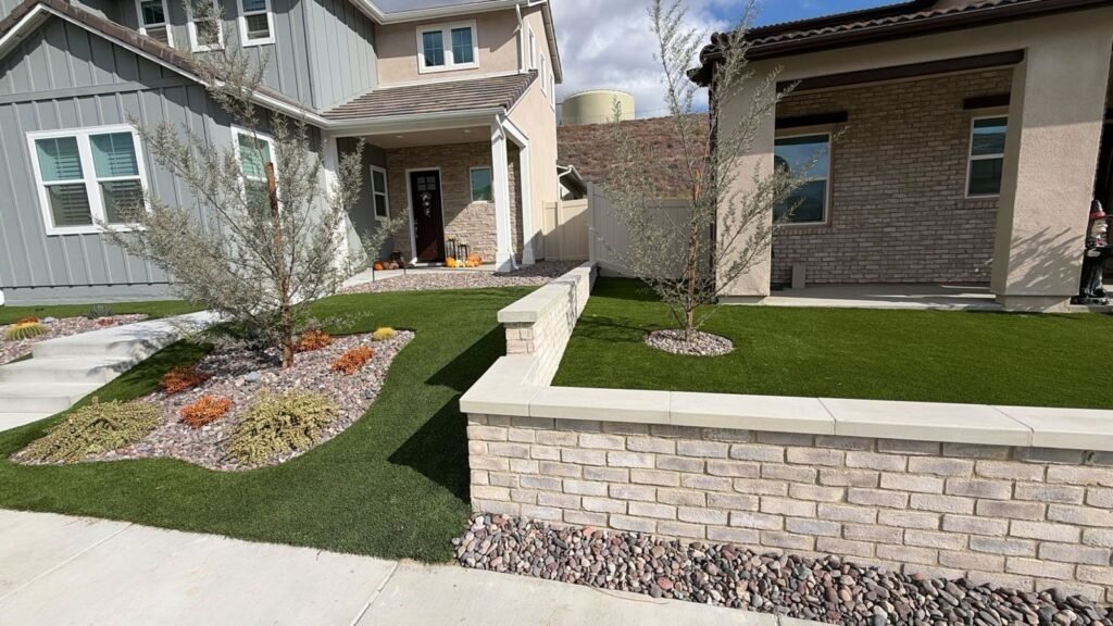 Two neighboring Santa Clarita front yards with artificial turf and a brick garden wall