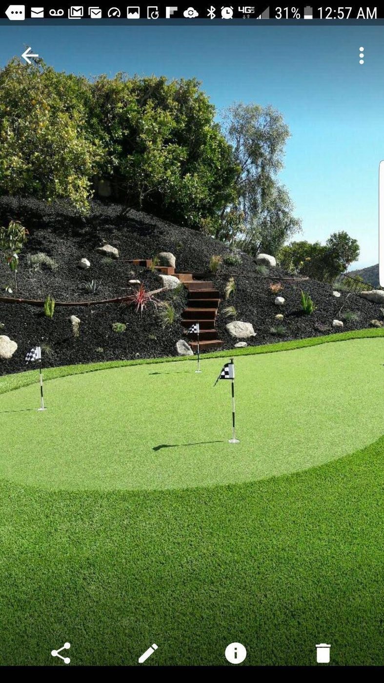 Backyard putting green installation in Tarzana below a planted hillside by Option 1 Builders